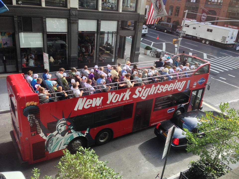 A sightseeing bus filled with Amish-looking folk.